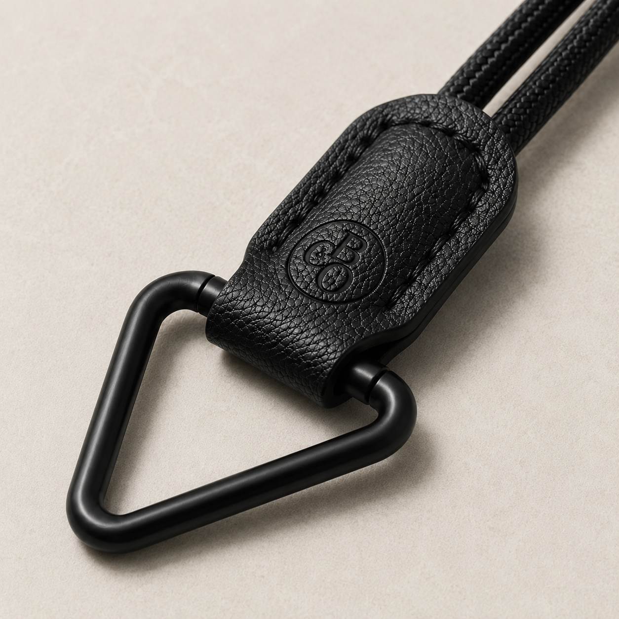 Close view of The Signature's matte-black triangular eyewear loop and embossed holder