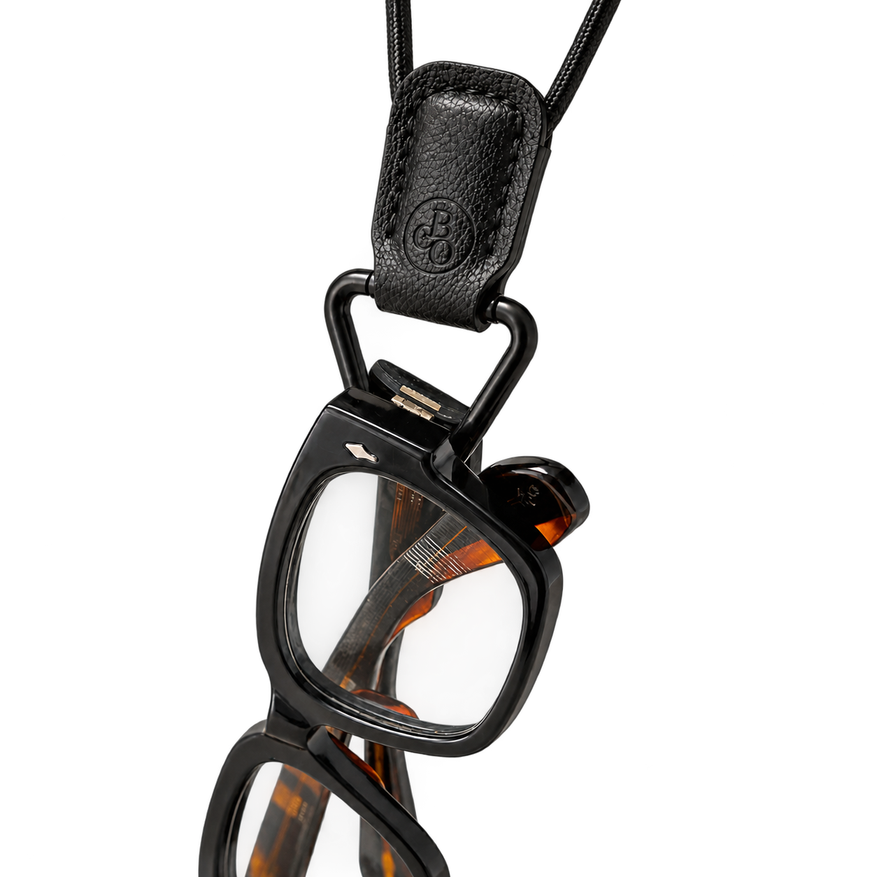 Thick acetate glasses placed through The Signature's matte-black triangular loop beneath its stitched holder