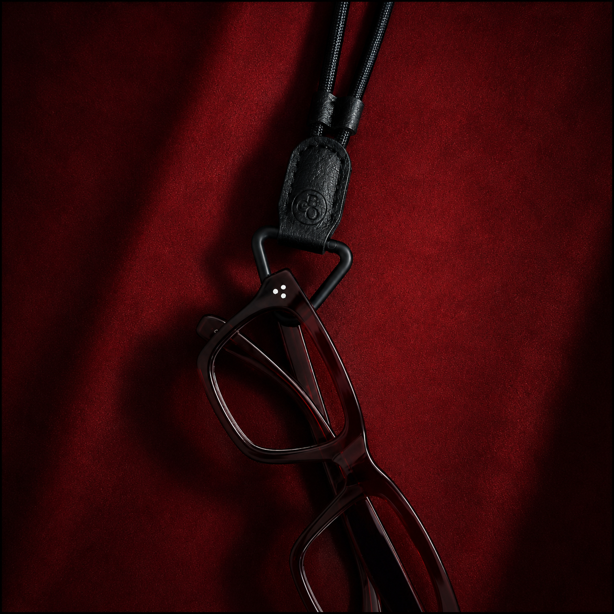 glasses hooked onto a black glasses-holder necklace